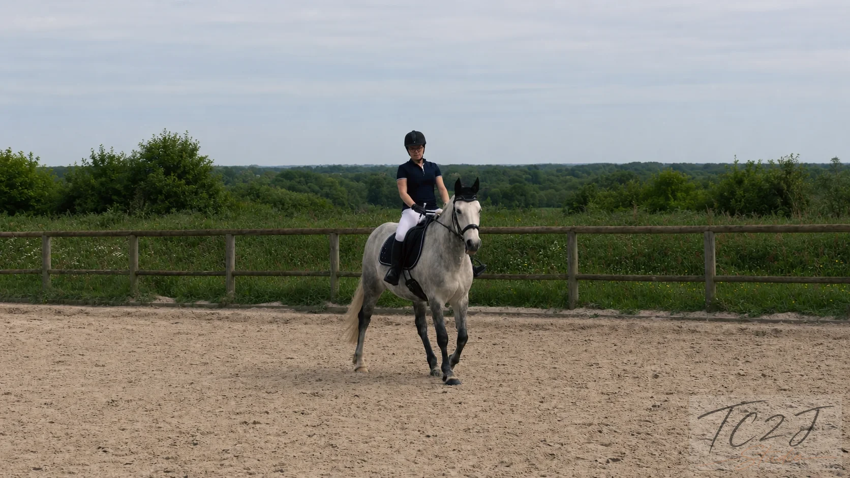 Cavalière sur un cheval dans une carrière